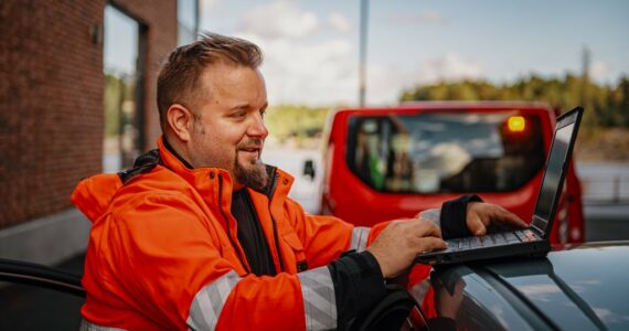 Tiepalvelumekaanikko tarkistaa auton merkkivaloja tietokoneella